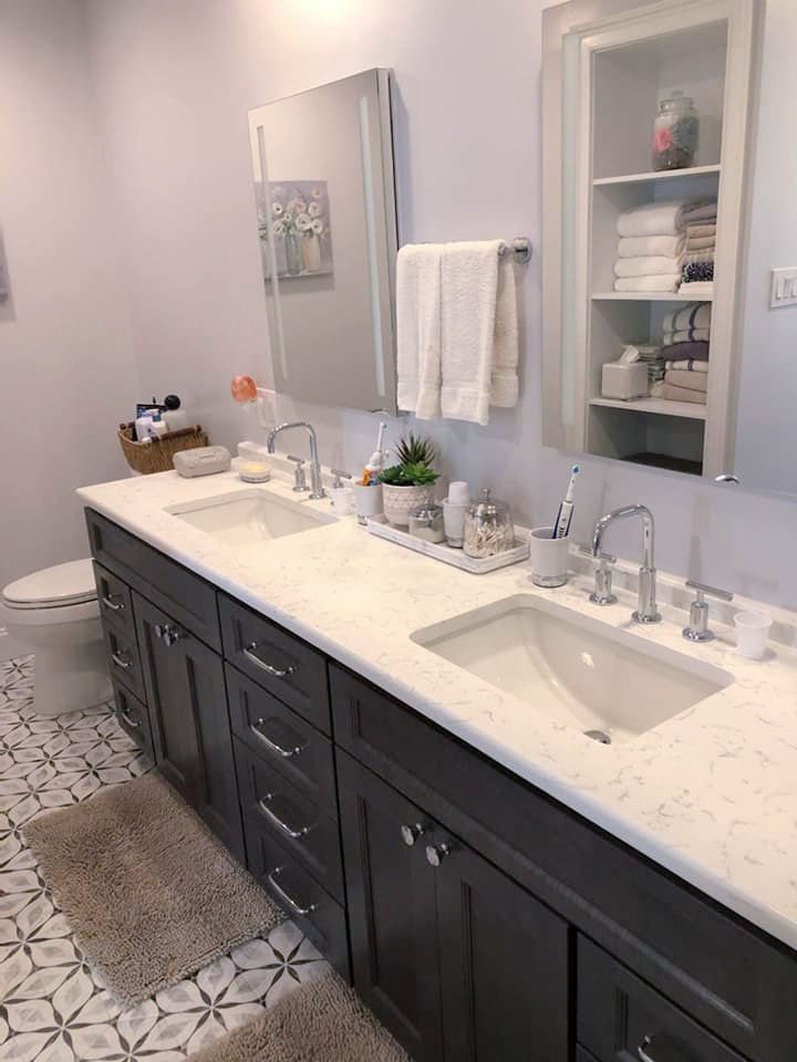 Dark double vanity with quartz top and penny tile floor