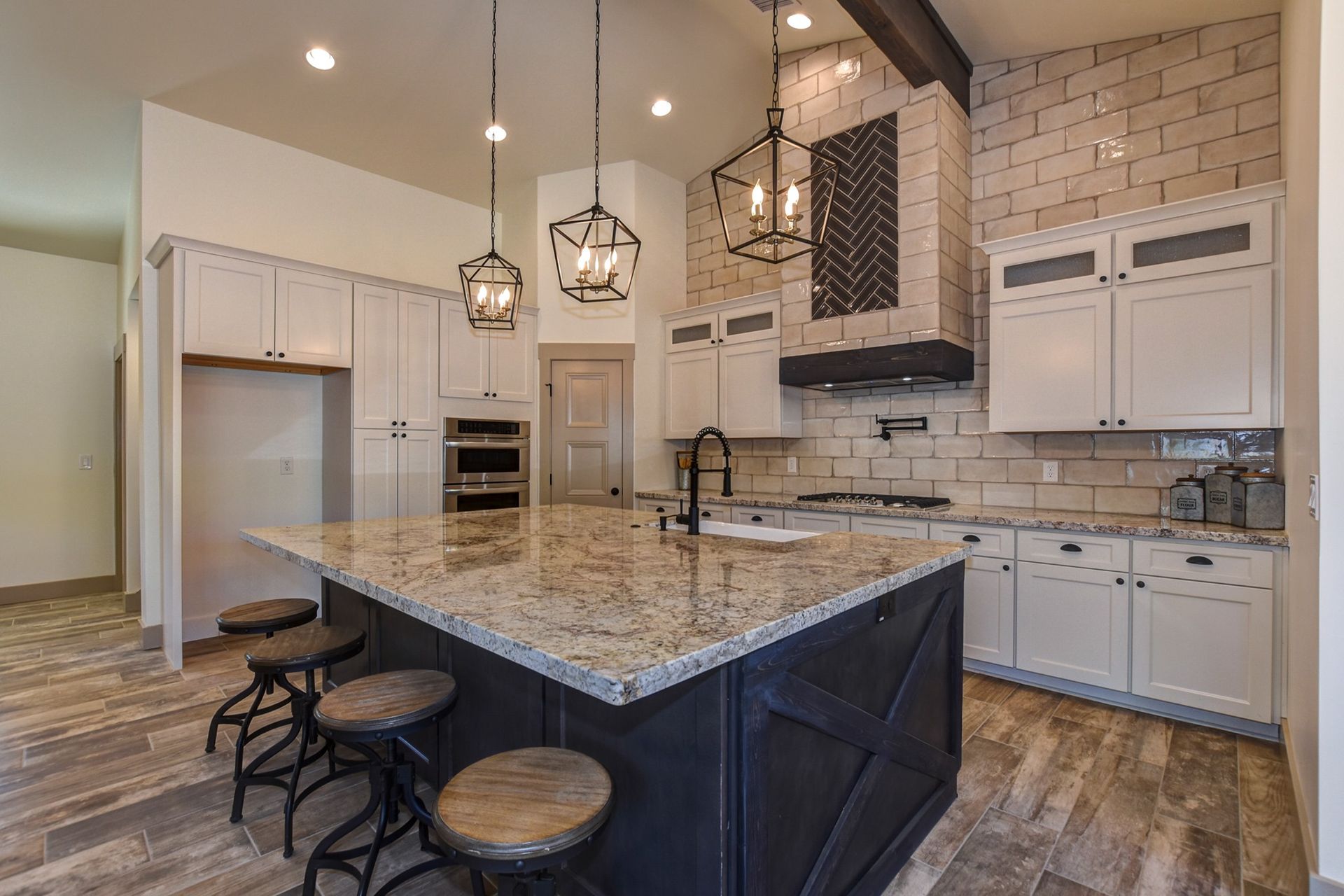 Kitchen remodel with under-lit island, glass tile, and pendant lighting